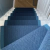 Herringbone Border stair runner in Petrol and Ink installed on a winding wooden staircase.
