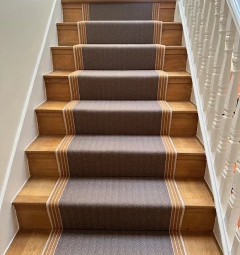 Tapis d'escalier tissé plat jaune et marron installé sur des escaliers droits en bois