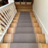 Yellow and brown flatweave stair runner installed on straight wooden stairs