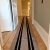 Black and beige flatweave stair runner installed on wooden landing