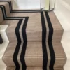 White wooden staircase with quarter landing featuring a striped PNT16 flatweave stair runner