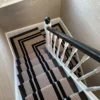 Dark wooden staircase with striped PNT16 flatweave stair runner