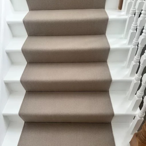Couloir d’escalier tissé à plat beige installé sur un escalier droit en bois