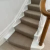 Couloir d’escalier tissé à plat beige installé sur un escalier droit en bois
