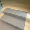 Beige flatweave stair runner installed on straight wooden flight of stairs