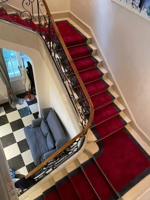 Hand-tufted stair runner in red and grey with golden stair rods