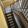 Black and white herringbone flatweave stair runner with a woven black border on brown staircase and landing.