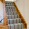 Tapis d’escalier tissé plat à rayures, installé sur des marches en bois