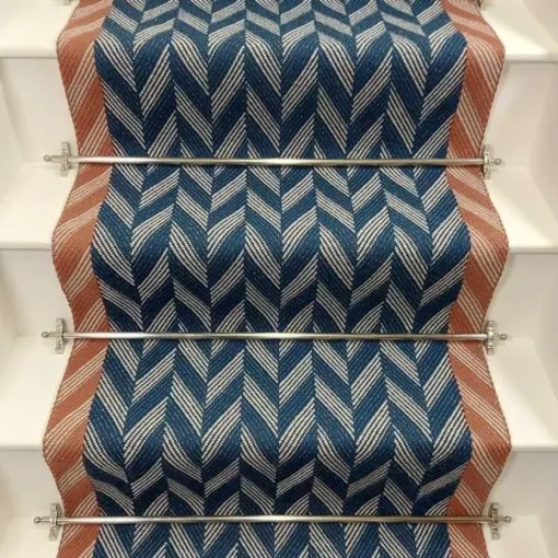 Blue Herringbone stair runner with orange woven border on white stairs