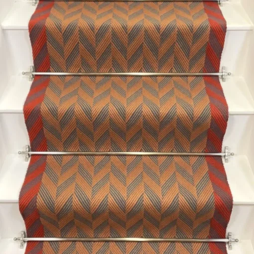 Cinnamon and Spruce Herringbone stair runner with vibrant red woven border on white stairs