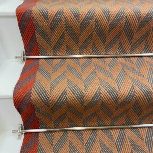 Cinnamon and Spruce Herringbone stair runner with vibrant red woven border on white stairs