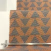 Cinnamon-coloured stair runner with green triangle pattern on white wooden stairs
