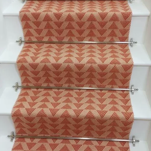 Light pink stair runner with triangle pattern on white wooden stairs