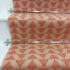 Tapis d'escalier rose pâle avec motif de triangles sur escaliers en bois blanc