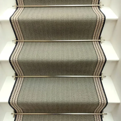 Tapis d’escalier plat vert avec bordure tissée blanche et grise sur des marches blanches.