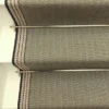 Tapis d’escalier plat vert avec bordure tissée blanche et grise sur des marches blanches.